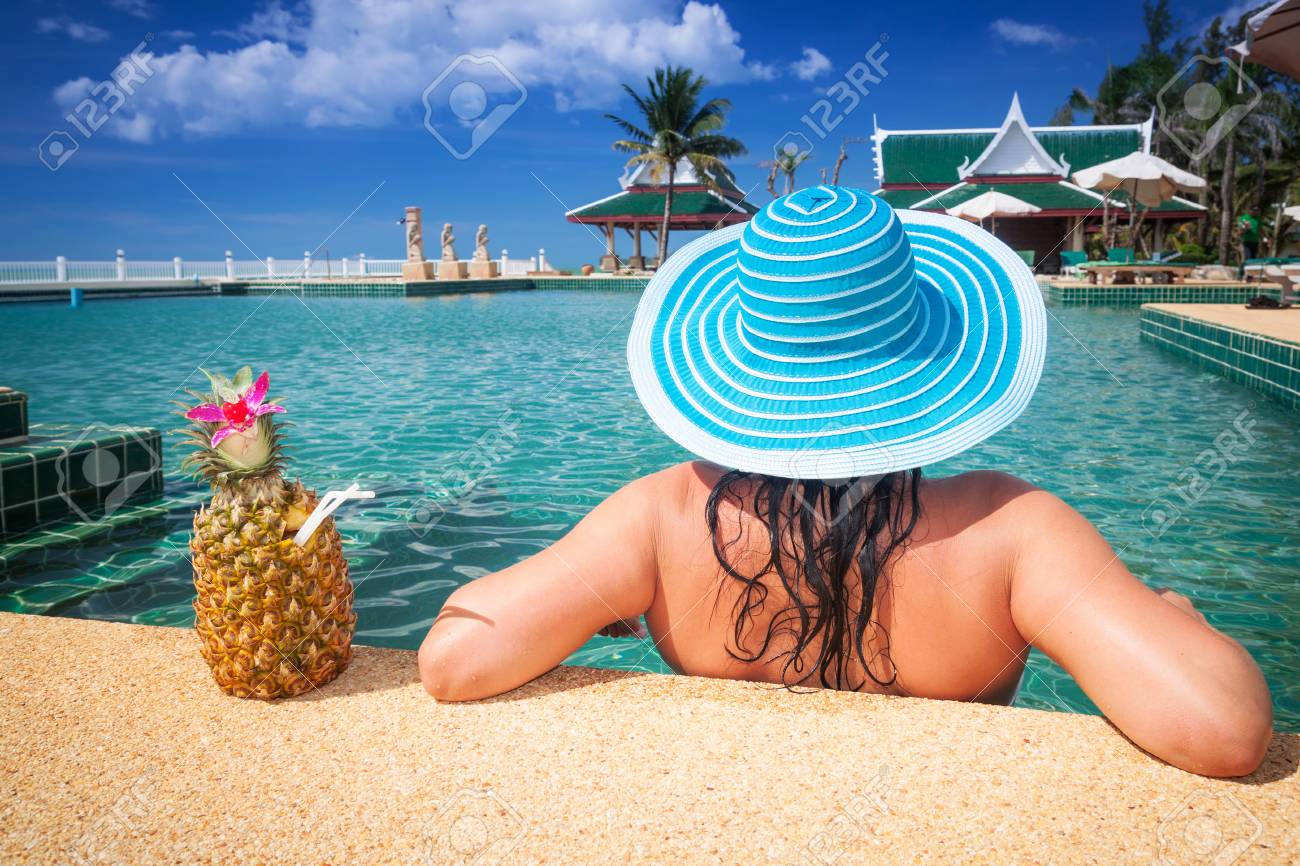 55673081-mujer-con-sombrero-disfrutando-de-bebida-de-piña-en-la-piscina.jpg