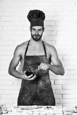 89101088-hombre-guapo-alegre-o-cocinero-muscular-panadero-en-gorro-de-chef-rojo-y-delantal-con...jpg