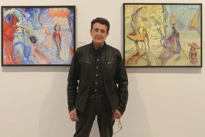 Manolo Garcia posando con sus cuadros.jpg